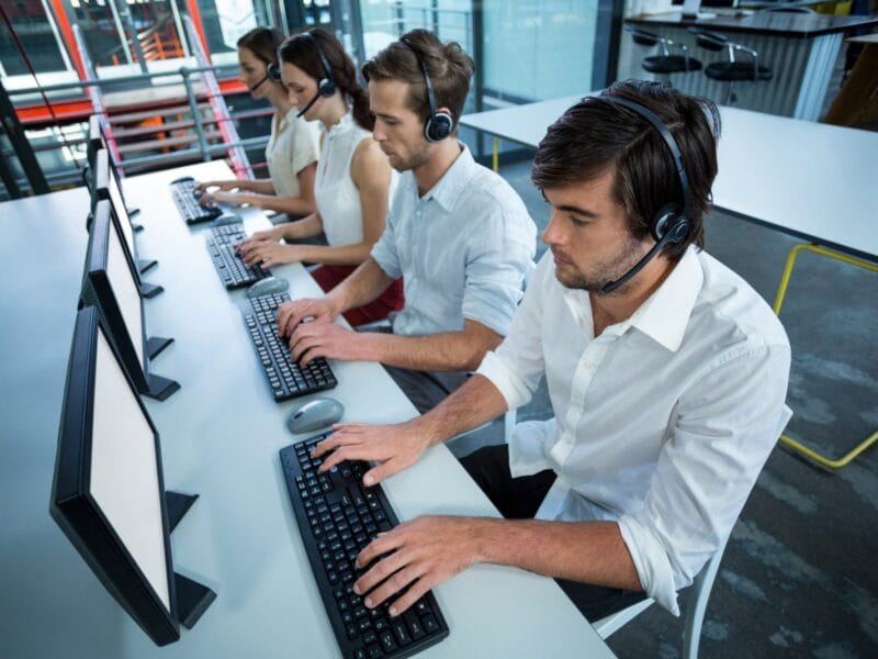 Business executives with headsets using computer